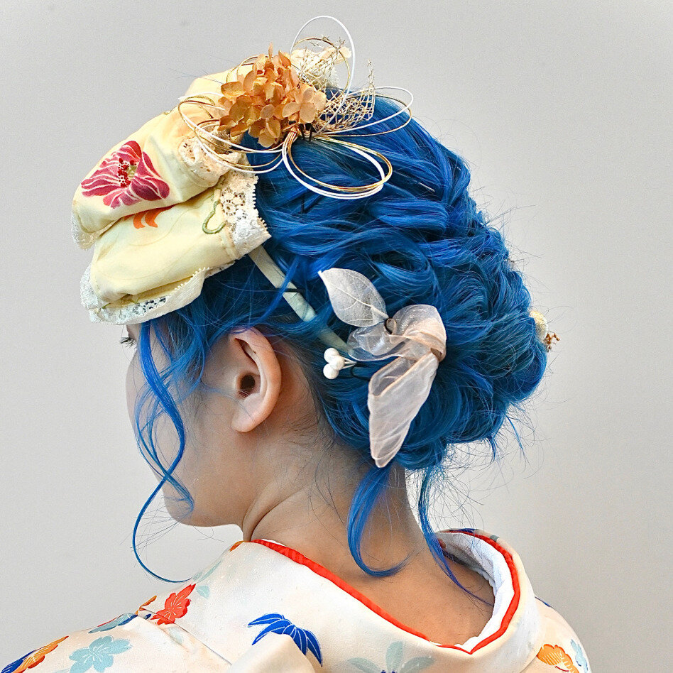 インパクト抜群のブルーヘアには、互いの色を最も引き立たせる補色のオレンジ系アクセを合わせて。